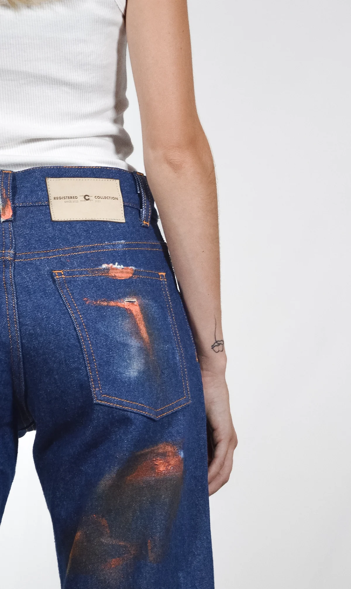 Back view of Fe26 jeans with rust-coloured treatments