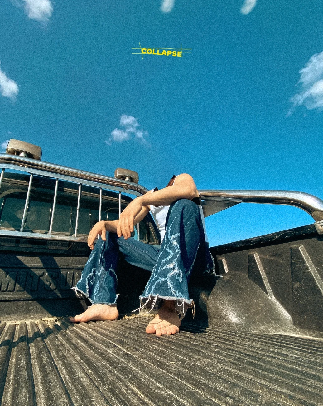 Original Fe26 image with a model seated in a pickup bed against a blue sky