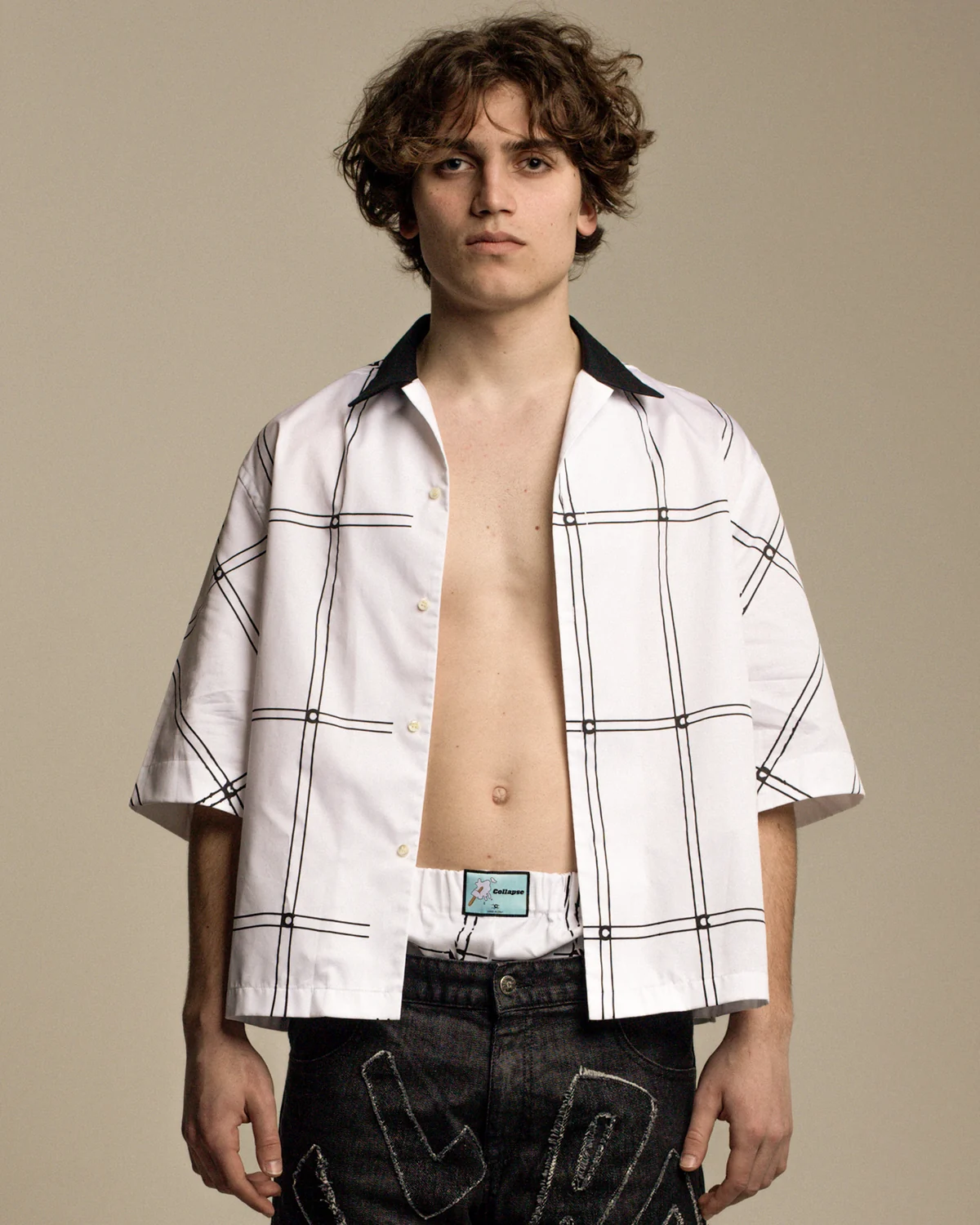 Model in a white shirt with graphic lines and dark denim