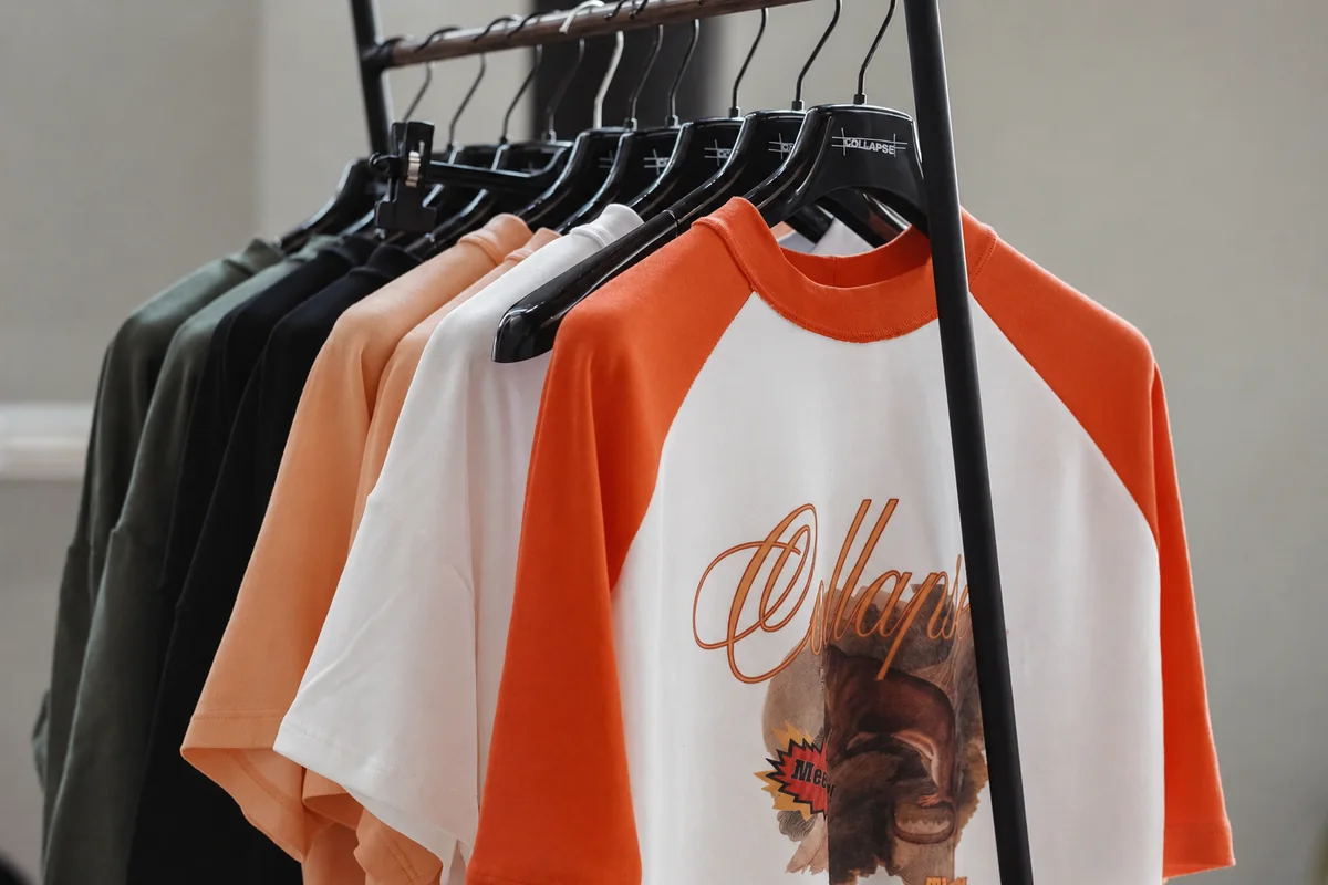 Capi della capsule sulle grucce COLLAPSE, dettaglio della T-shirt raglan