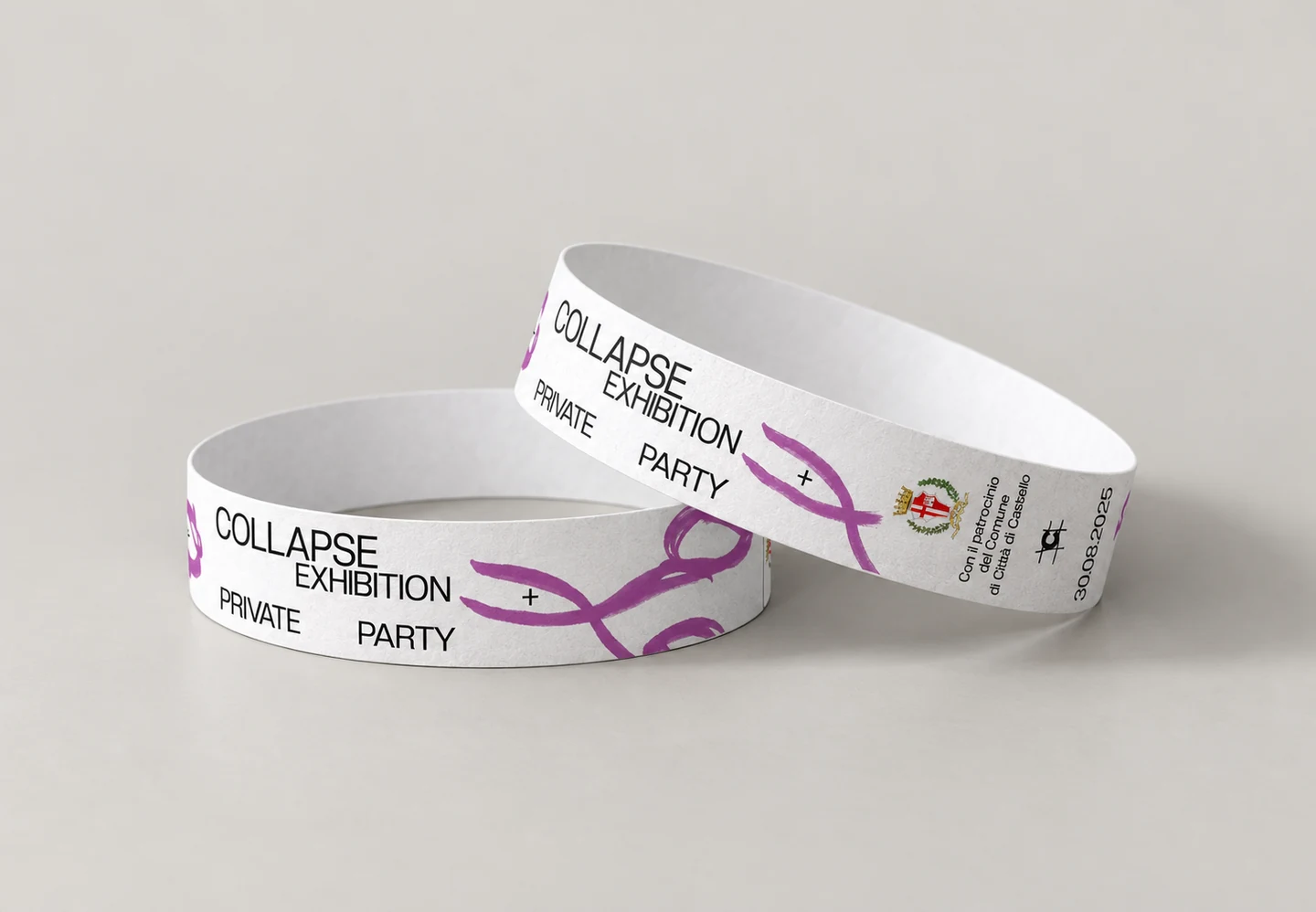 Mockup of two overlapping paper COLLAPSE wristbands with black and purple print