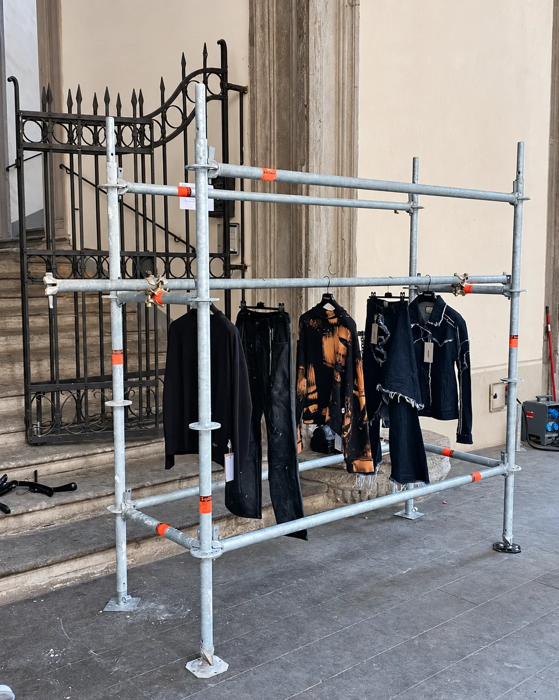 COLLAPSE garments displayed on a modular metal structure